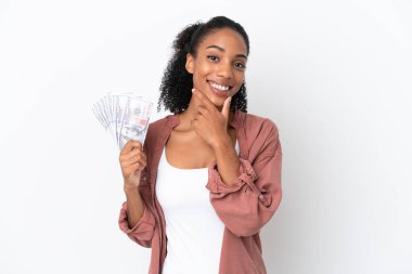 Genç Afrikalı Amerikalı bir kadın beyaz arka planda izole edilmiş bir sürü para alıyor mutlu ve gülümsüyor.
