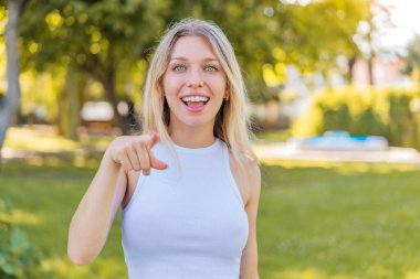 Dışarıdaki sarışın kadın şaşırmış ve ön tarafı işaret ediyor.