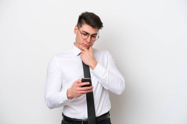 Beyaz arka planda izole edilmiş beyaz bir iş adamı düşünüyor ve bir mesaj gönderiyor.