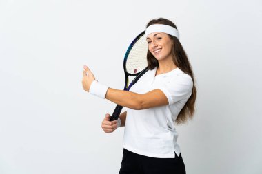 İzole edilmiş beyaz arka planda genç bayan tenis oyuncusu geriye doğru işaret ediyor