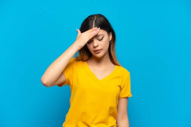 Mavi arka planda başağrısı olan genç bir kız.