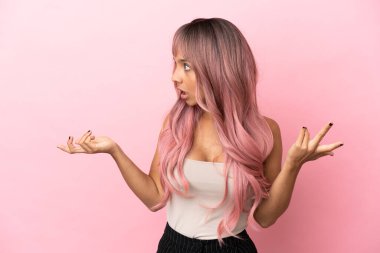 Pembe saçlı melez bir kadın. Pembe arka planda. Sürpriz bir ifadeyle.