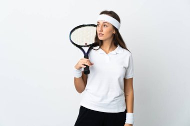Genç bayan tenisçi, izole edilmiş beyaz arka plan üzerinden yan tarafa bakıyor.