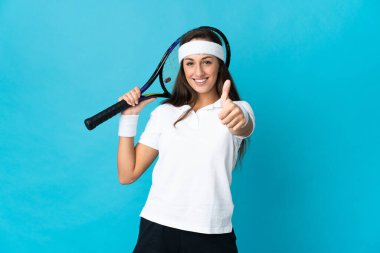 Soyutlanmış mavi arka planda tenis oynayan genç İspanyol kadın.