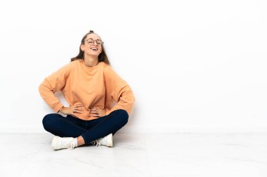 Silah, kalça ile poz ve gülümseyen katta oturan genç kadın