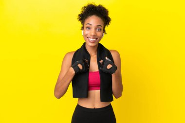 Genç Afrikalı sporcu kadın, sarı arka planda şaşırmış bir yüz ifadesiyle izole edilmiş.