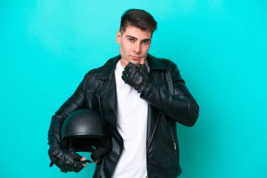 Motosiklet kasklı beyaz bir adam mavi arka planda izole edilmiş.