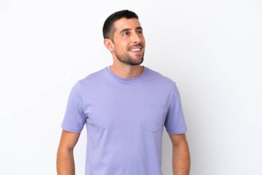 Beyaz arka planda izole edilmiş yakışıklı beyaz adam yukarı bakarken bir fikir düşünüyor.