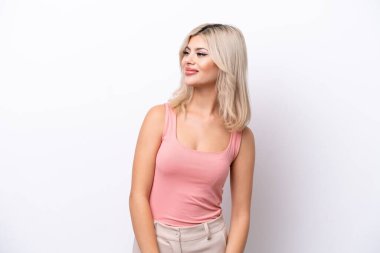 Beyaz arka planda soyutlanmış genç bir kadın yan bakıyor ve gülümsüyor.