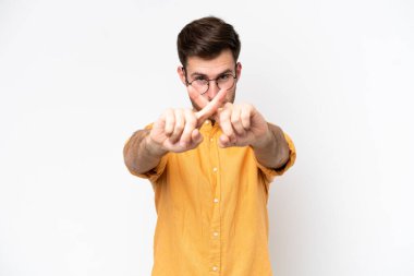 Beyaz arka planda izole edilmiş genç beyaz bir adam bir eylemi durdurmak için eliyle jesti durduruyor.