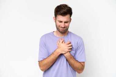 Beyaz arka planda izole edilmiş genç beyaz bir adam kalbinde bir ağrı var.