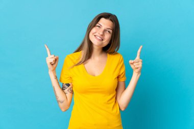 Mavi arka planda izole edilmiş genç Slovak kadın harika bir fikre işaret ediyor.