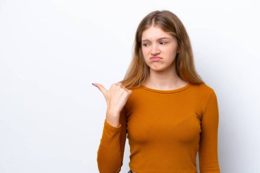 Genç Rus kız, beyaz arka planda izole edilmiş mutsuz ve kenarı işaret ediyor.