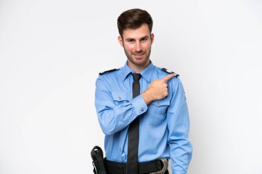 Beyaz arka planda izole edilmiş genç bir beyaz adam bir ürün sunmak için kenarı işaret ediyor.