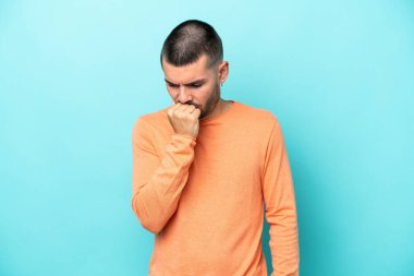 Kafkasyalı genç adam mavi arka planda izole edilmiş. Şüpheleri var.