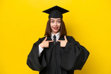 Genç üniversite mezunu Ukraynalı kadın, sarı arka planda şaşırmış bir yüz ifadesiyle izole edilmiş.