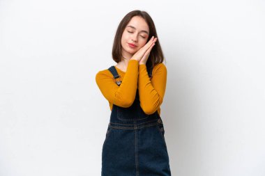 Beyaz arka planda izole edilmiş genç Ukraynalı bir kadın uyku jesti yapıyor.