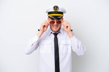 Kafkasyalı uçak pilotu beyaz arka planda gözlüklü ve şaşırmış.