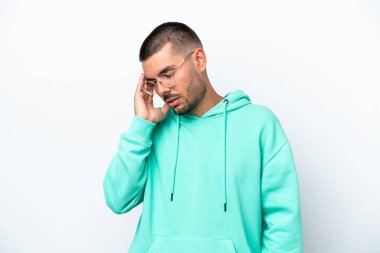 Beyaz arka planda başı ağrıyan genç beyaz bir adam.