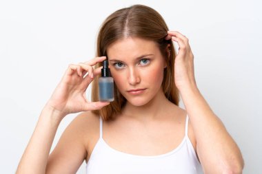 Beyaz arka planda izole edilmiş beyaz bir kadın elinde bir serum tutuyor. Portreyi kapat