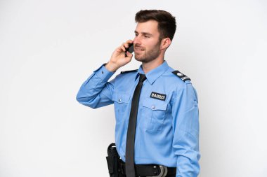 Young police caucasian man isolated on white background keeping a conversation with the mobile phone