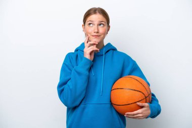 Beyazların arka planında basketbol oynayan beyaz bir kadın yukarı bakarken bir fikir düşünüyor.