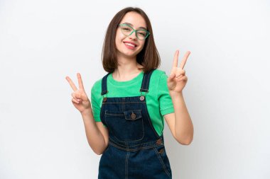 Beyaz arka planda izole edilmiş genç Ukraynalı kadın iki eliyle zafer işareti gösteriyor.