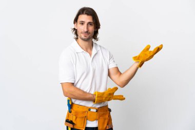 İzole edilmiş arka planda genç elektrikçi. Davet etmek için ellerini yana uzatıyor.
