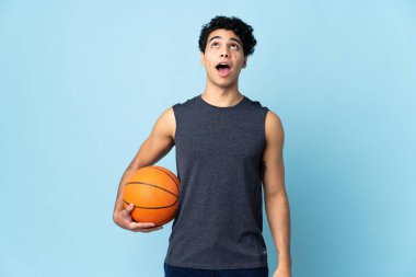 Venezuelalı basketbolcu izole edilmiş arka planda yukarı bakıyor ve şaşırmış bir ifadeyle