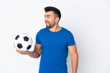 Yakışıklı genç futbolcu, duvarın diğer tarafına bakıyor.