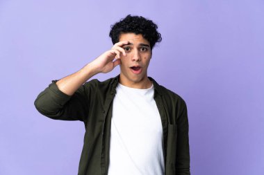 Genç Venezuelalı adam mor arka planda izole bir şey fark etti ve çözüme niyetlendi.