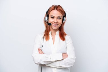 Beyaz arka planda izole edilmiş bir kulaklıkla çalışan pazarlamacı Rus kız kollarını ön cephede çapraz tutuyor.