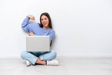 Dizüstü bilgisayarı olan, beyaz arka planda izole edilmiş beyaz bir kadın güçlü bir jest yapıyor.