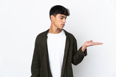 İzole edilmiş beyaz arkaplan üzerinde genç bir adam kopyalama alanını şüpheyle tutuyor