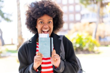 Afro-Amerikalı bir kız elinde bir pasaport, şaşırmış bir ifadeyle.
