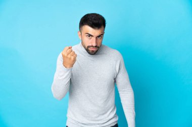 Mutsuz bir ifadeyle izole edilmiş mavi arka planı olan beyaz bir adam.