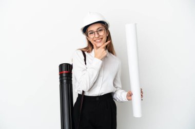 Kasklı ve elinde planları olan genç mimar kadın beyaz arka planda izole edilmiş mutlu ve gülümsüyor.