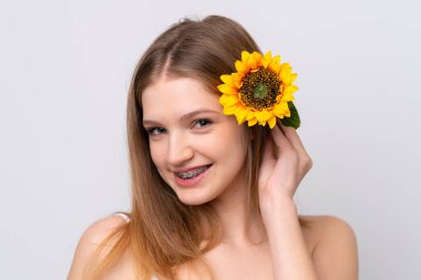 Beyaz arka planda izole edilmiş genç Rus kız gülümseyerek elinde bir ayçiçeği tutuyor. Portreyi kapat