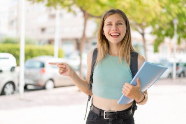 Açık havada genç sarışın bayan şaşırdı ve işaret etti.