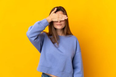 Young Slovak woman isolated on yellow background covering eyes by hands. Do not want to see something