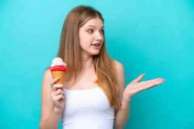 Kornet dondurması olan genç bir Rus kız. Mavi arka planda yalıtılmış ve yüzünde sürpriz bir ifade var.