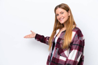 Beyaz arka planda soyutlanmış beyaz tenli genç bir kadın davet edilmek için ellerini yana uzatıyor.