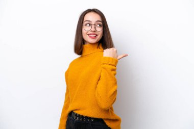 Beyaz arka planda izole edilmiş genç Ukraynalı kadın bir ürünü sunmak için kenarı işaret ediyor