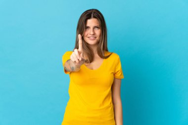 Mavi arka planda izole edilmiş genç Slovak kadın ciddi ifadeli birini sayıyor