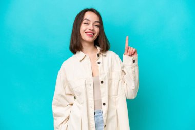 Mavi arka planda izole edilmiş genç Ukraynalı kadın en iyinin işareti olarak parmağını kaldırıyor ve gösteriyor.
