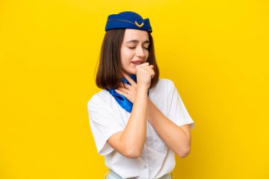 Uçak hostesi Ukraynalı kadın sarı arka planda izole edilmiş öksürük çekiyor ve kötü hissediyor.