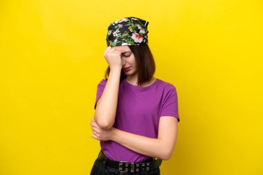 Genç Ukraynalı kadın sarı arka planda izole edilmiş, baş ağrısı var.