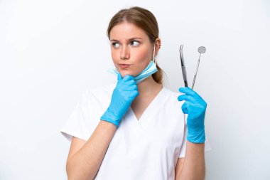 Beyaz arka planda izole edilmiş aletler tutan beyaz dişçi kadın şüpheleri var.