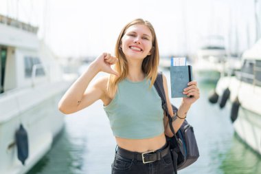 Açık havada pasaportu olan genç sarışın kadın gururlu ve kendini beğenmiş.