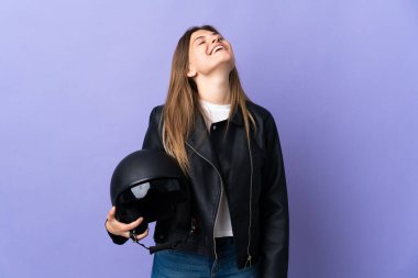 Mor arka planda izole edilmiş motosiklet kaskı tutan genç Slovak kadın gülüyor.